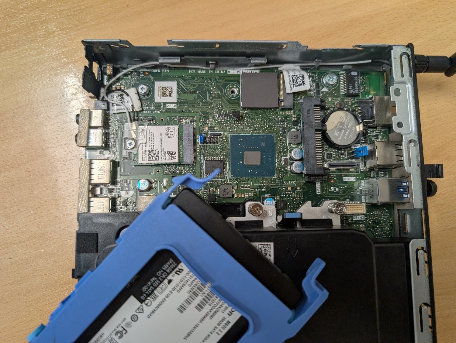 Photo of a small Dell motherboard, showing an unused M.2 slot, a standard SATA socket, and another M.2 slot with a networking card in it.