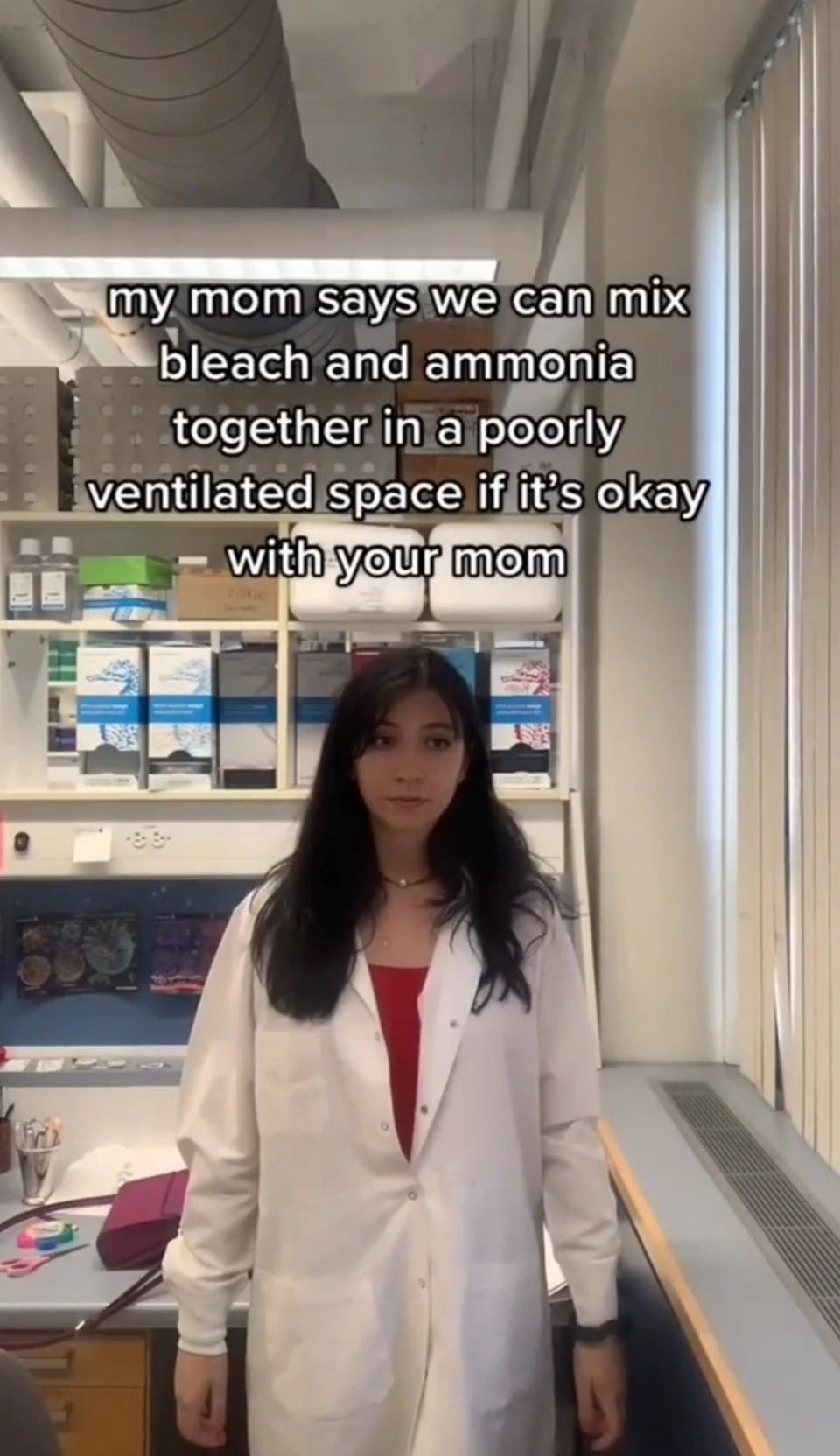 Woman wearing a labcoat, standing and looking blankly past the camera, with the caption, “my mom says we can mix bleach and ammonia together in a poorly ventilated space if it's okay with your mom”