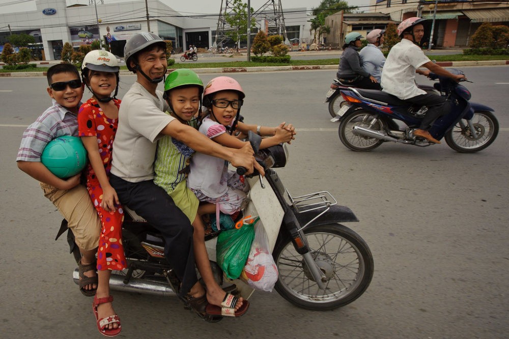 An image of 5 people riding one motorbike.