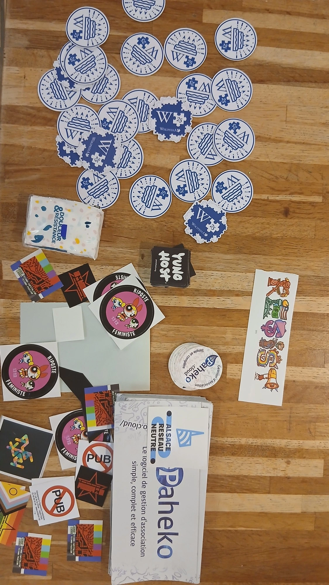 A table full of stickers : wikipedia, anarchist symbol with keyboard, lgtbqia+ flag