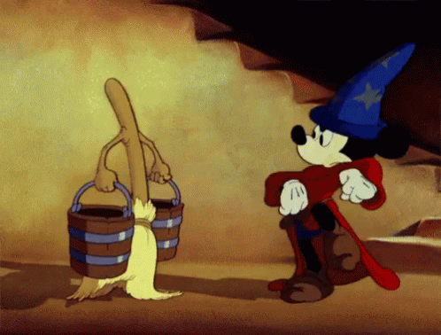 Gif of a scene from Disney's The Sorcerer's Apprentice. Mickey Mouse is wearing the sorcerer's hat, and has imbued a broom to life with its magic. He's marching on the spot in front of it, imploring it to mimic him, as it grew arms and carries buckets of water for him.
