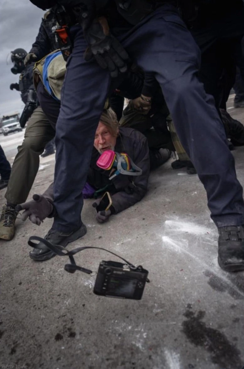 Getty photographer throwing his camera to another photographer while being tackled in Minneapolis (USA) to prevent confiscation.