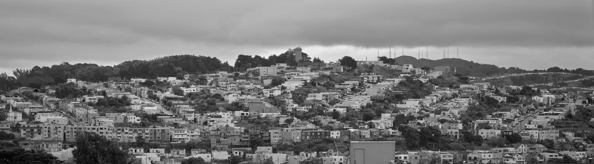 A panoramic view of a hillside in San Francisco, covered mostly in small mid-century residential houses.