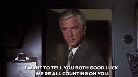image GIF from movie Airplanes where character played by Leslie Nielson says I want to wish you both good luck. We're all counting on you.