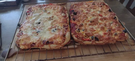 two pizzas on cooling on a rack