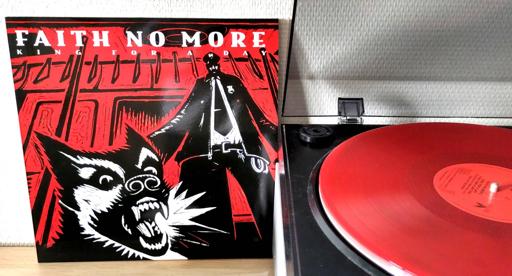 Album cover in stark red, black and white art by Eric Drooker (from his book "Flood"). Next to it, the red vinyl spinning on the turntable.