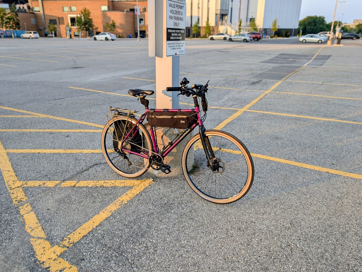 A photo of a bicycle with a purple frame, black fork and tires with tan sidewalls