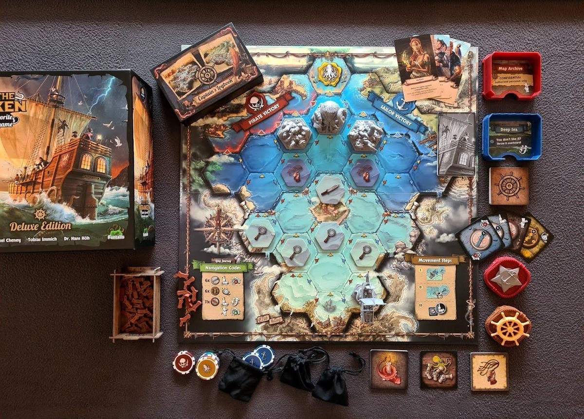 Game components laid out next to a closed box which reads "Feed the Kraken -
Deluxe Edition"