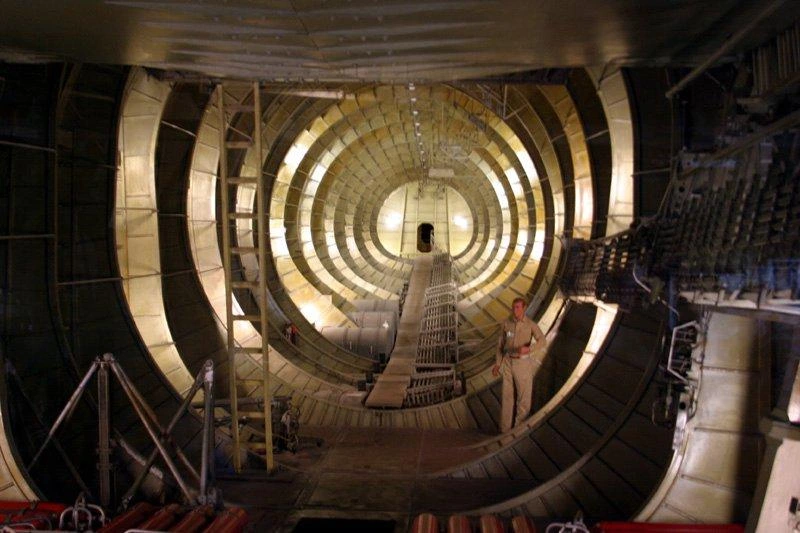 A view like the interior of a large, ribbed tunnel, which is looking from the front of the Spruce Goose interior towards the back.