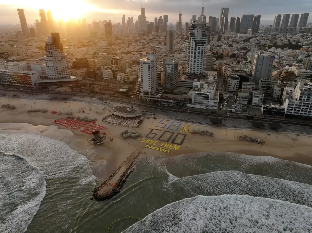 An aerial view of Tel Aviv, with the sign on the sand reading: 58x600, Save them now!