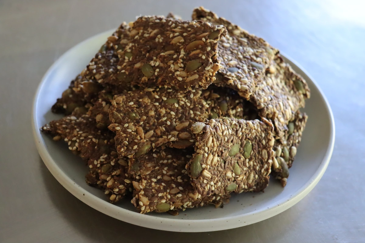 white plate of seed crackers piled high in good light