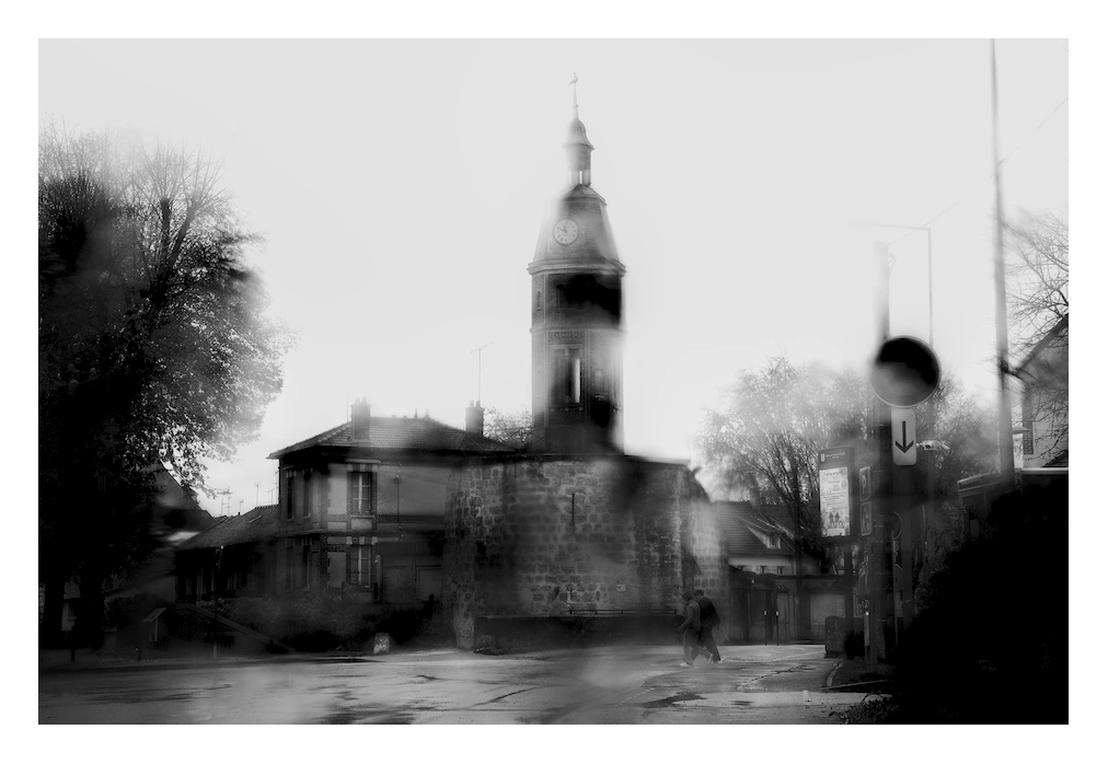 Monochrome rainy daylight photography.
Remaining of ancient fortifications seen from street level, the little village doesn't know if it had to swallow it entirely or not, time remains proudly in control at the top of a tower ... of course...