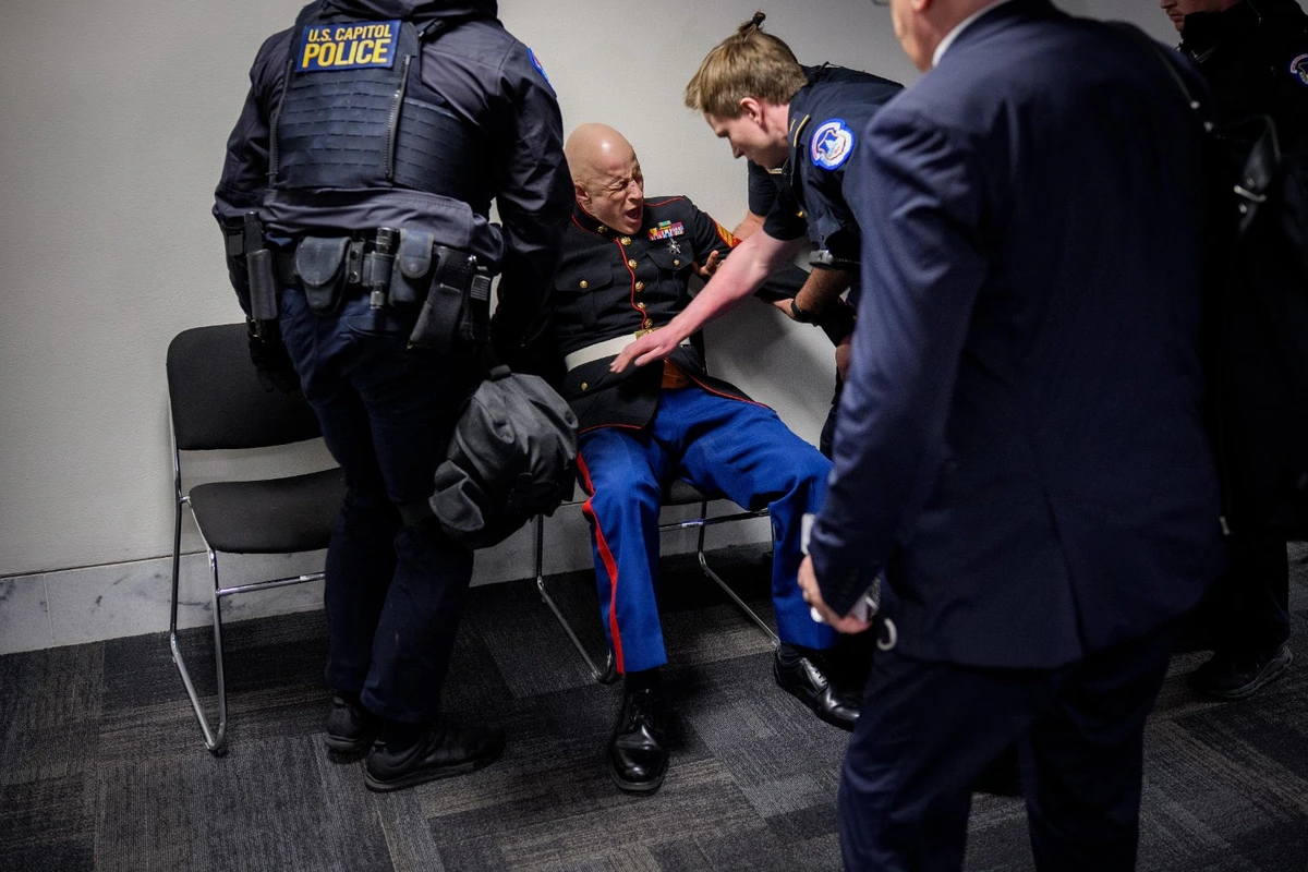Marine Corps Veteran McGinnis reacts to his broken arm after a forced removal for protesting